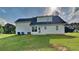 Back exterior view of home with lush lawn and bright sky at 64 Dogwood Rdg, Hampton, GA 30228