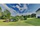 Scenic backyard with a serene pond and expansive green space perfect for outdoor activities at 64 Dogwood Rdg, Hampton, GA 30228