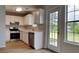 Modern kitchen showcasing stainless steel appliances, white cabinets, and a door to backyard at 64 Dogwood Rdg, Hampton, GA 30228