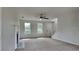 Bright living room features a ceiling fan, plush carpet, and staircase access at 64 Dogwood Rdg, Hampton, GA 30228