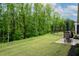 Spacious backyard featuring a well-manicured lawn, a patio area, and a view of the wooded surrounding at 109 Aspen Way, Dallas, GA 30157