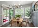Bright dining area with natural light, wooden table, neutral chairs and a door leading to a sunroom at 109 Aspen Way, Dallas, GA 30157