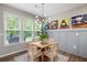 Cozy dining area bathed in natural light, featuring wood table, neutral chairs and cat-themed art at 109 Aspen Way, Dallas, GA 30157