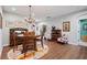 A dining area featuring a round wooden table, hardwood floors, elegant wall decor, and a view of other rooms at 109 Aspen Way, Dallas, GA 30157