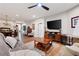 An open-concept living room featuring hardwood floors, a ceiling fan, and access to a dining area at 109 Aspen Way, Dallas, GA 30157