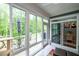 Bright sunroom with comfortable seating, cat tree, an outdoor dining area and access to the backyard at 109 Aspen Way, Dallas, GA 30157