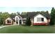 The home's exterior is beautifully landscaped with trees, grass, and flowering shrubs at 250 Mayfield Rd, Alpharetta, GA 30009
