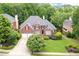 Two-story brick home with a two-car garage, lush lawn, and mature trees at 3348 Perrington Pointe, Marietta, GA 30066