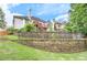 Multi-tiered backyard with stone retaining wall, deck, lush lawn, and mature landscaping at 3348 Perrington Pointe, Marietta, GA 30066