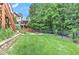 Lush backyard features a stone fire pit, a manicured lawn, and mature trees at 3348 Perrington Pointe, Marietta, GA 30066