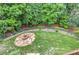 Manicured backyard featuring a unique stone fire pit, privacy fence, and mature trees at 3348 Perrington Pointe, Marietta, GA 30066
