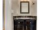 Stylish powder room features a dark vanity with marble countertop and decorative mirror at 3348 Perrington Pointe, Marietta, GA 30066