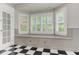 Bright breakfast nook featuring a bay window, custom shutters, built-in bench with storage, and black and white checkerboard floors at 3348 Perrington Pointe, Marietta, GA 30066