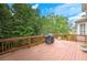Large, stained wood deck overlooking a private, wooded backyard featuring a grill and green trees at 3348 Perrington Pointe, Marietta, GA 30066
