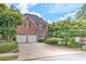 Brick home with a two-car garage and a spacious driveway surrounded by manicured shrubs at 3348 Perrington Pointe, Marietta, GA 30066