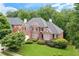 Beautiful brick home featuring a well-manicured lawn, lush greenery, and a classic design at 3348 Perrington Pointe, Marietta, GA 30066