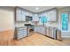 Updated kitchen with gray cabinets, granite countertops, stainless steel appliances, and hardwood flooring at 3480 Stillridge Dr, Alpharetta, GA 30022