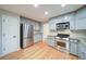 Modern kitchen featuring stainless steel appliances, light gray cabinetry, and hardwood floors throughout the space at 3480 Stillridge Dr, Alpharetta, GA 30022