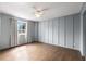 This spacious bedroom has wood flooring, panelled walls, and a window with curtains at 3501 Roswell Ne Rd # 102, Atlanta, GA 30305