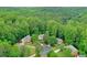 Aerial view of neighborhood houses surrounded by dense forest at 9900 Hunt Club Way, Johns Creek, GA 30022