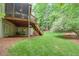 Backyard view of the house with grass and mulch at 9900 Hunt Club Way, Johns Creek, GA 30022