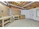 Unfinished basement with wooden work benches and a white door to the outside at 9900 Hunt Club Way, Johns Creek, GA 30022