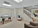 Spacious basement features a foosball table, staircase, and cozy seating area at 9900 Hunt Club Way, Johns Creek, GA 30022
