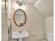 Elegant half bathroom with a pedestal sink and a vintage mirror and vanity lights at 9900 Hunt Club Way, Johns Creek, GA 30022