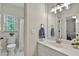 Bright bathroom with a single vanity, white cabinets, a shower and tub combo and natural light at 9900 Hunt Club Way, Johns Creek, GA 30022