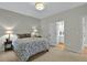 Comfortable bedroom with neutral walls, carpeting, a queen sized bed and access to an ensuite bathroom at 9900 Hunt Club Way, Johns Creek, GA 30022