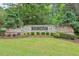 Stone monument sign marks the entrance to the Fox Creek community with lush landscaping and mature trees at 9900 Hunt Club Way, Johns Creek, GA 30022