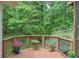 Inviting outdoor deck adorned with colorful potted flowers and picturesque backyard views at 9900 Hunt Club Way, Johns Creek, GA 30022