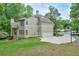 Side exterior of home with large driveway and well-manicured lawn at 9900 Hunt Club Way, Johns Creek, GA 30022