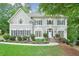 Beautiful two-story home with a manicured front yard, lush landscaping, and charming architectural details at 9900 Hunt Club Way, Johns Creek, GA 30022