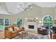 Bright living room featuring a vaulted ceiling, large windows, comfortable seating, and a fireplace at 9900 Hunt Club Way, Johns Creek, GA 30022