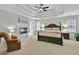Comfortable main bedroom with tray ceiling, ceiling fan, fireplace, and sitting area at 9900 Hunt Club Way, Johns Creek, GA 30022