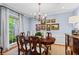 Elegant dining room featuring a chandelier, hardwood floors, and large window providing ample natural light at 1518 Rochelle Dr, Atlanta, GA 30338