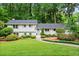 Charming white home with lush green lawn and mature trees providing a serene and inviting curb appeal at 1518 Rochelle Dr, Atlanta, GA 30338