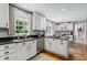 Well-lit kitchen with white cabinets, stainless steel appliances, and hardwood floors creating a modern aesthetic at 1518 Rochelle Dr, Atlanta, GA 30338