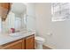 Well-lit bathroom featuring a wood vanity, a window, and a toilet for your convenience at 171 Nacoochee Way, Canton, GA 30114