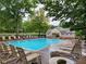 Relaxing community pool featuring lounge chairs, tables, and mature trees in a serene neighborhood setting at 171 Nacoochee Way, Canton, GA 30114