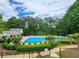 Community pool with clear blue water and plenty of lounge seating in a landscaped outdoor setting at 171 Nacoochee Way, Canton, GA 30114