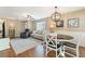 Comfortable living area with elegant furniture, a dining table, and hardwood floors, illuminated by modern lighting at 171 Nacoochee Way, Canton, GA 30114