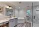 Bright bathroom with a glass shower, soaking tub, and vanity with gray cabinets at 178 Mission Oak Dr, Grayson, GA 30017