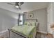 Cozy bedroom features a wood-frame bed, a ceiling fan, and floral curtains over the window at 178 Mission Oak Dr, Grayson, GA 30017