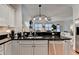 Open kitchen with black countertops, white cabinets, stainless steel appliances, and hardwood flooring at 178 Mission Oak Dr, Grayson, GA 30017