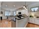 Bright kitchen with white cabinets, black countertops, island, pendant lights, and stainless steel appliances at 178 Mission Oak Dr, Grayson, GA 30017