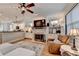 Bright living room with fireplace, kitchen view, white couch, and stylish ceiling fan at 178 Mission Oak Dr, Grayson, GA 30017