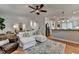 Spacious living room showcasing the open layout with kitchen, white couch, and modern ceiling fan at 178 Mission Oak Dr, Grayson, GA 30017
