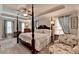 Spacious primary bedroom featuring a canopy bed, tray ceiling, and sitting area at 178 Mission Oak Dr, Grayson, GA 30017